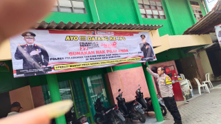 Pemasangan Banner Himbauan Ajakan Datang ke TPS oleh Bhabinkamtibmas Sidotopo Wetan
