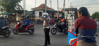 Personel Polsek Asemrowo Atur Arus Lalu Lintas di Simpang Rel KA Tambak Mayor Demi Kelancaran dan Keamanan Pengguna Jalan