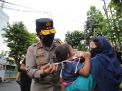 Kapolda Jatim Bagikan Beras dan Kenakan Masker Pada Anak Kecil Yang Tak Kenakan Masker