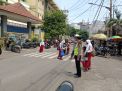 Polsek Krembangan Lakukan Pengaturan Lalu Lintas Sore di Depan SDN Perak Barat, Bantu Siswa Siswi Menyebrang Jalan
