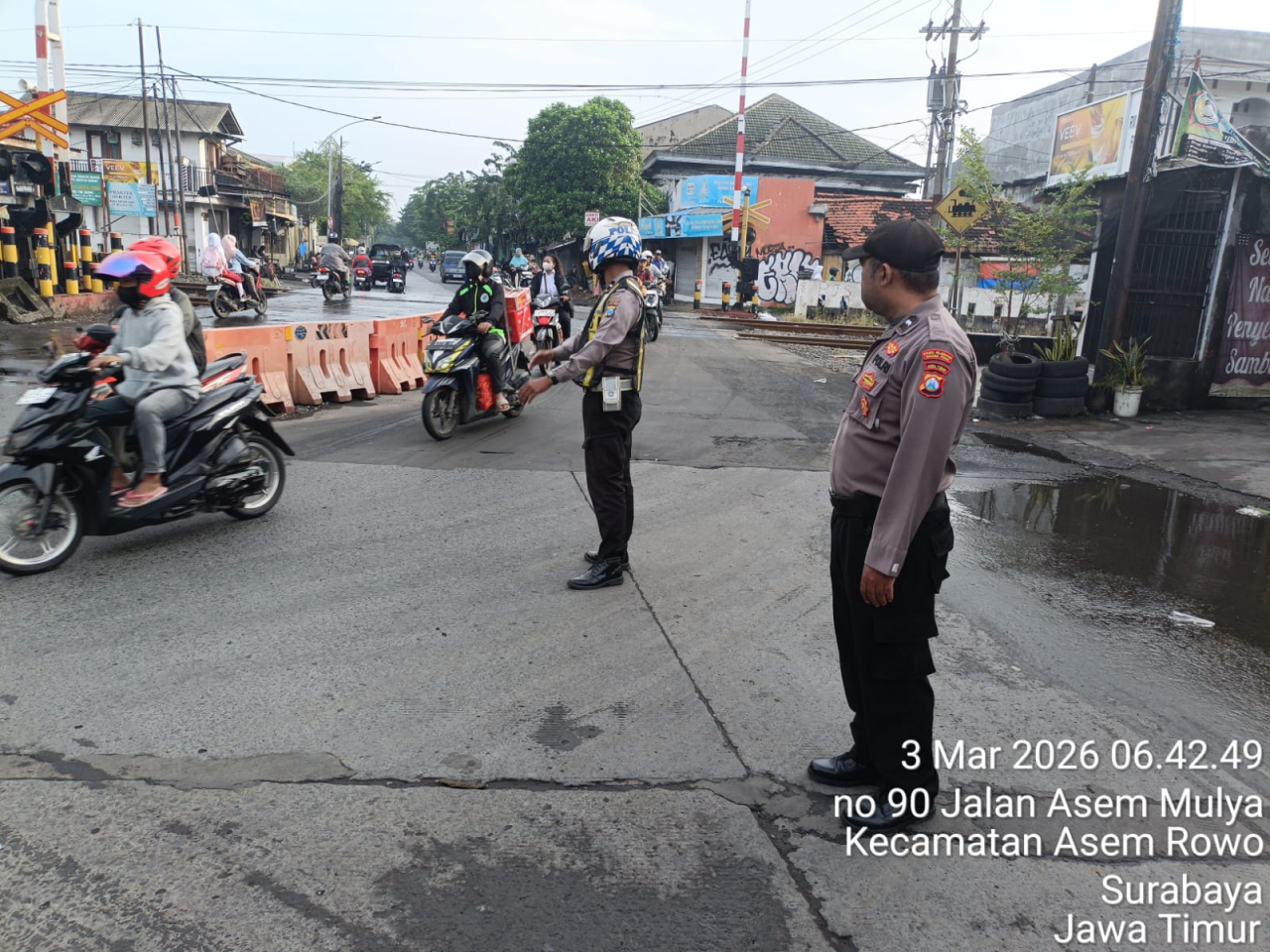 Pelayanan Pagi Polsek Asemrowo di Perlintasan Kereta Api Jalan Tambak Mayor Pastikan Arus Lalu Lintas Lancar dan Aman