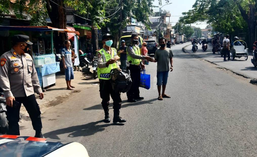 Kapolsek Semampir Bersama Personil Bagikan Nasi Bungkus Kepada Penarik Becak & PKL di Jalan Karang Tembok