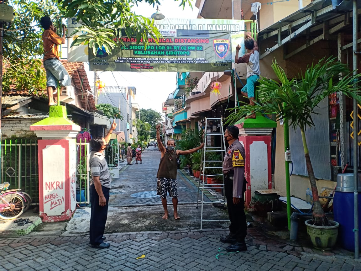 Kanit Reskrim Polsek Semampir Pantau Pemasangan Spanduk Kawasan Physical Distancing